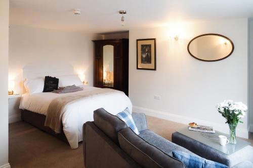 a bedroom with a bed and a couch and a mirror at The Horngarth in Whitby