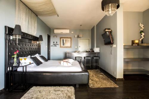 a bedroom with a bed and a table and a bar at Ahuzat Van Gogh in Kefar Weradim