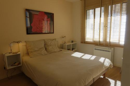 a bedroom with a white bed and a window at Au 21 in Avignon