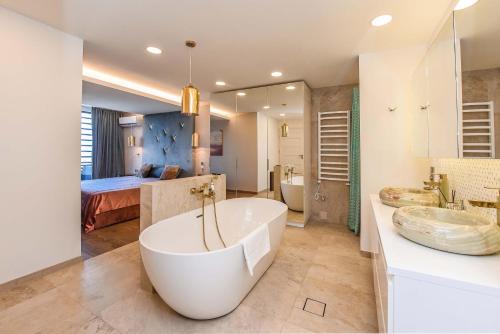 a bathroom with a tub and a bedroom with a bed at Palanga Sea View in Palanga