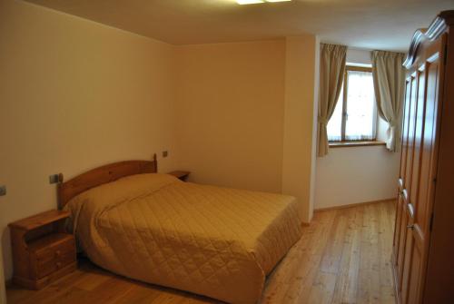 a bedroom with a bed and a wooden floor at Casa Vacanza La Rocca in Chiesa in Valmalenco