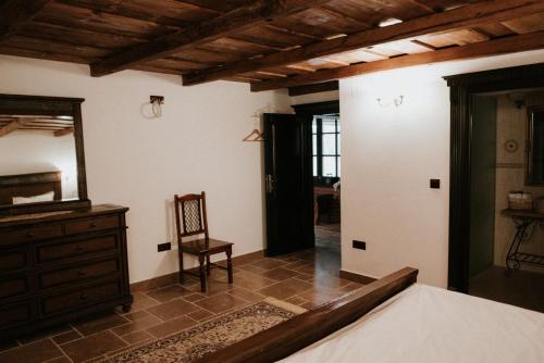 a bedroom with a dresser and a mirror and a chair at La Saca 42 in Saca