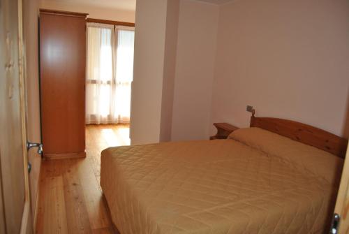 a bedroom with a bed and a wooden floor at Casa Vacanza La Rocca in Chiesa in Valmalenco