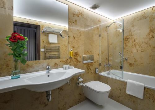 ein Badezimmer mit einem Waschbecken, einem WC und einem Spiegel in der Unterkunft Clementin in Prag