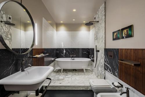 a bathroom with a white tub and a sink and a bath tub at Locanda Pandenus Brera in Milan