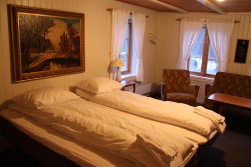 a bedroom with a bed and a painting on the wall at Heddan Gjestegard in Tingvatn