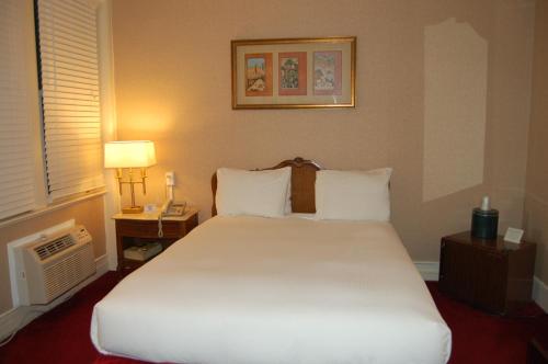 เตียงในห้องที่ Windsor Inn Hotel