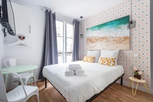 niewielka sypialnia z łóżkiem i stołem w obiekcie Apartments WS Opéra - Galeries Lafayette w Paryżu