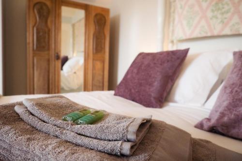 a towel and pillows on a bed with a mirror at The Horngarth in Whitby