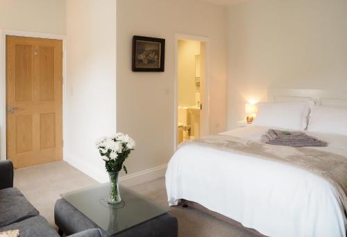 a bedroom with a bed and a table with a vase of flowers at The Horngarth in Whitby
