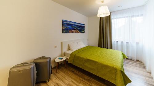 a bedroom with a bed and two suitcases in it at Riga Airport Jurmala apartments in Rīga