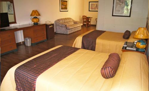 a hotel room with two beds and a couch at Suites Colibri in Oaxaca City