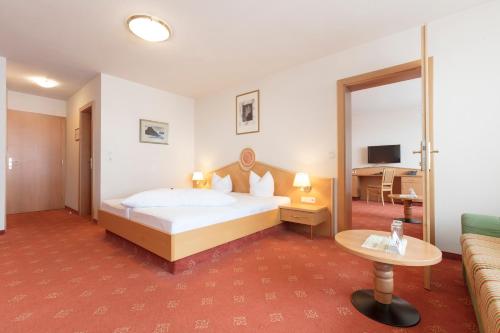 a hotel room with a bed and a couch at Hotel Andreas Hofer in Sankt Leonhard im Pitztal