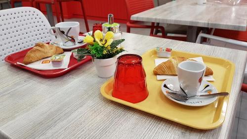 a tray with a plate of food on a table at The Originals Access, Hôtel les Iris, Berck-sur-Mer in Berck-sur-Mer