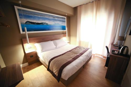 a bedroom with a bed with a painting on the wall at 7th Floor Suite in Naples