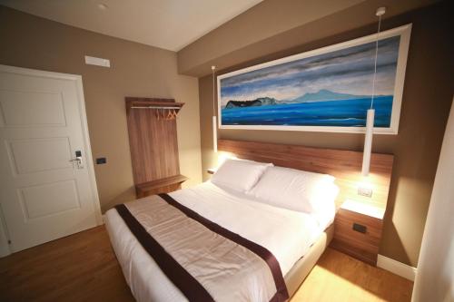 a bedroom with a bed with a painting on the wall at 7th Floor Suite in Naples