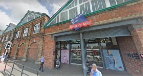 a store front of a brick building with people walking outside at Swindon City Centre Duplex - EnterCloud9SA in Swindon