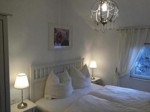 Schlafzimmer mit einem Bett mit weißer Bettwäsche und Kissen in der Unterkunft Das Ferienhaus mit Aussicht in Pirna