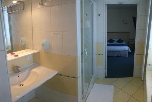 a bathroom with a shower and a sink and a shower at Logis Hotel Le Parc in Moulins