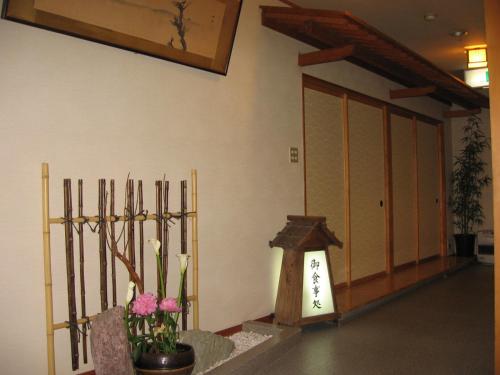 a room with a temple with a door and flowers at Yudanaka Yasuragi in Yamanouchi
