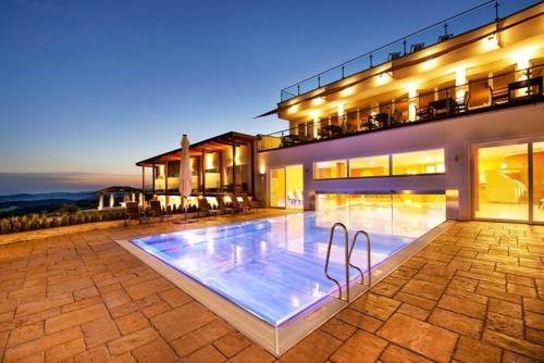 a swimming pool in front of a house at Revita Hotel Kocher in Sankt Agatha