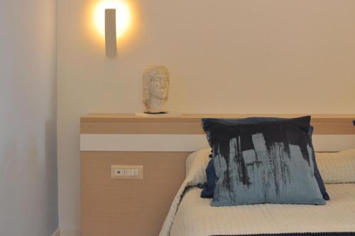 a bedroom with a bed with a headboard and a light at Casa Mao in Amalfi