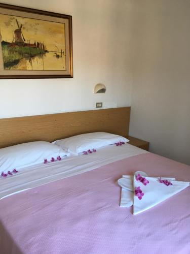 a bedroom with two beds with pink flowers on them at Hotel Peonia in Rimini