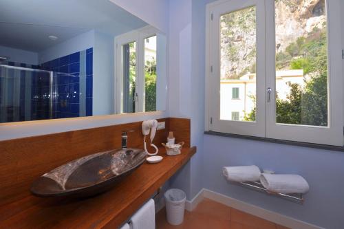 baño con lavabo grande y 2 ventanas en Casa Mao en Amalfi