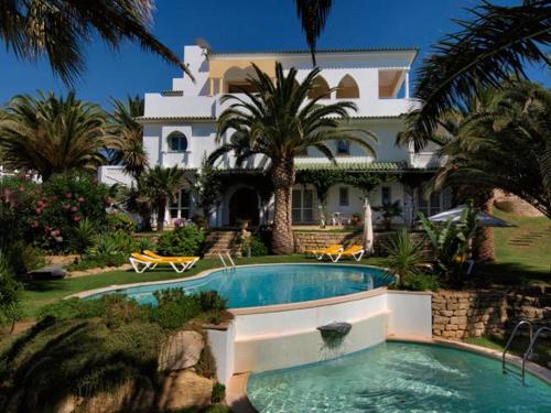 ein großes Haus mit einem Pool vor einem Haus in der Unterkunft Villa Esmeralda in Lagos