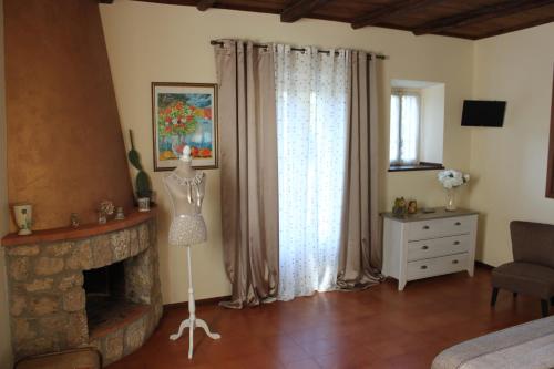 a room with a fireplace and a mannequin in front of a window at bed and breakfast "il Picchio Verde" in Cittaducale