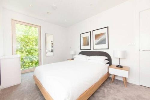 a white bedroom with a large bed and a window at Bright and Spacious 2 Bed Apartment- London Bridge ZONE 1 in London