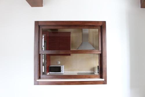 a window with a microwave sitting inside of it at Casa Pedrosa in Mondoñedo