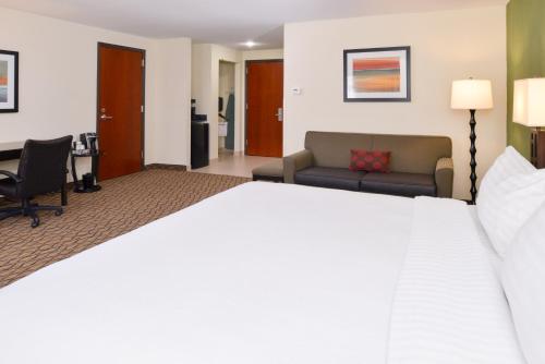 a hotel room with a large bed and a desk at Holiday Inn Poplar Bluff by IHG in Poplar Bluff