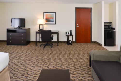 a hotel room with a desk and a chair at Holiday Inn Poplar Bluff by IHG in Poplar Bluff