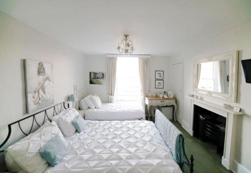 1 dormitorio con 2 camas y chimenea en No 4 Ainslie's Belvedere B&B, en Bath