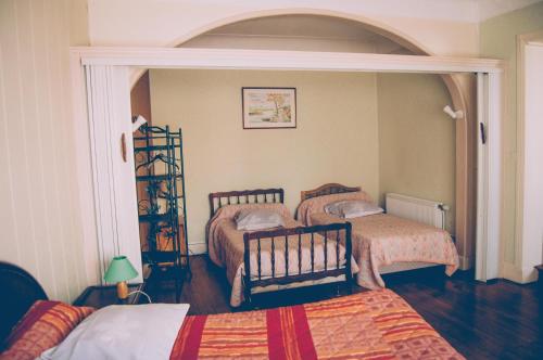 a bedroom with two beds and an arched doorway at Hotel Restaurant Maurice in Châteauroux