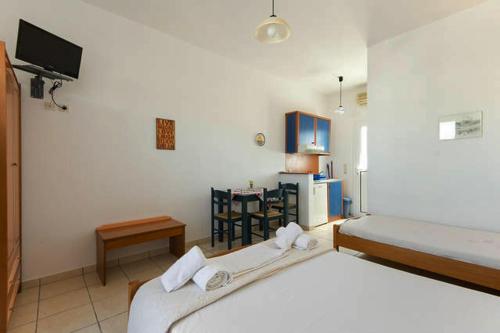 LivadiにあるContaratos Holiday Lettings 3のベッドルーム1室(ベッド2台、小さなテーブル付)