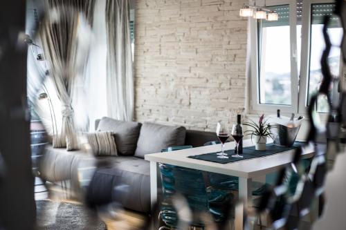 a living room with a couch and a table with wine glasses at Bubbles Penthouse with Jacuzzi in Podstrana