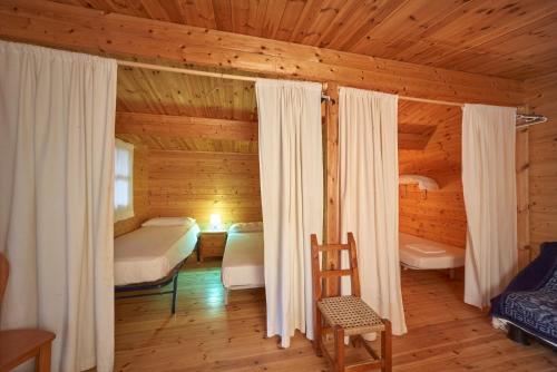 a bedroom in a log cabin with two beds at Camping Escana in Es Cana
