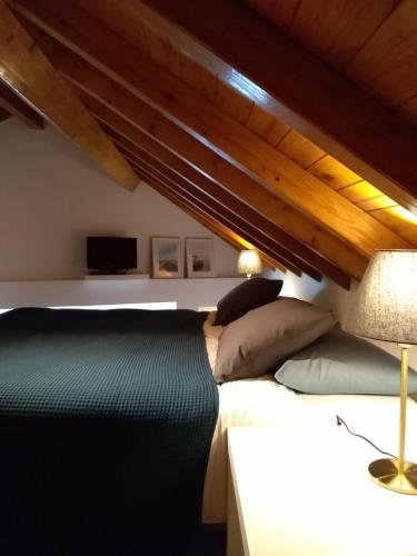 a bedroom with a bed under a wooden ceiling at Casa do Tejo de Alcochete in Alcochete