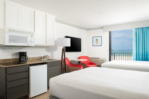 una camera d'albergo con due letti e una cucina di Bilmar Beach Resort a St Pete Beach
