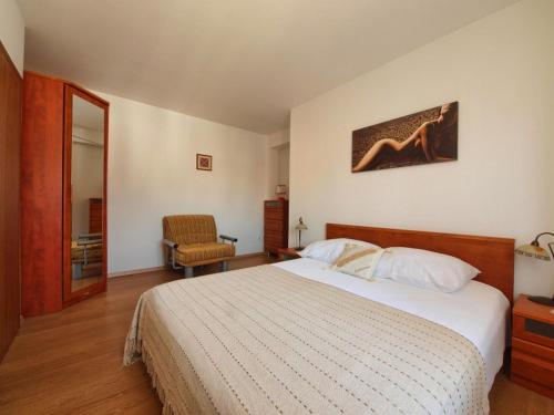 een slaapkamer met een groot bed en een stoel bij Apartments Anuška in Cavtat