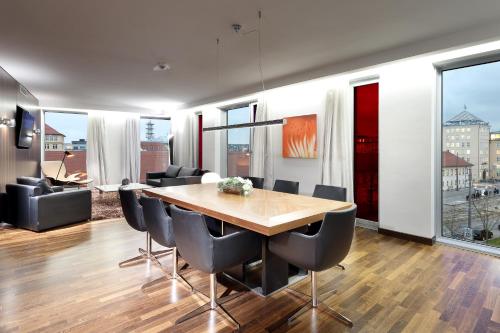 a dining room with a wooden table and chairs at Eurostars Grand Central in Munich
