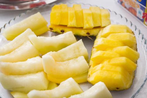 a plate of cut up pineapple on a table at JC Hotel in Rome