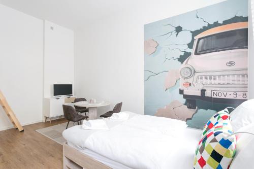 ein Schlafzimmer mit einem Bett und einem Wandbild eines Van in der Unterkunft Studio Apartment for 3 in Berlin