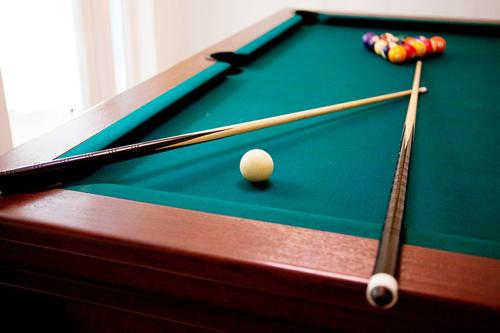 a pool table with two cue sticks and a ball at Penzión Modrý Dom in Modra
