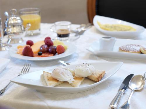 a white table with plates of food on it at Hotel Barocco in Rome