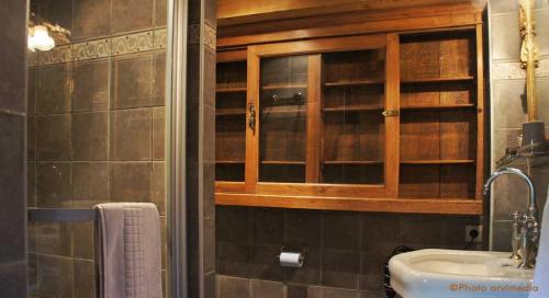 a bathroom with a sink and a wooden cabinet at Chalet le 1791 in La Clusaz