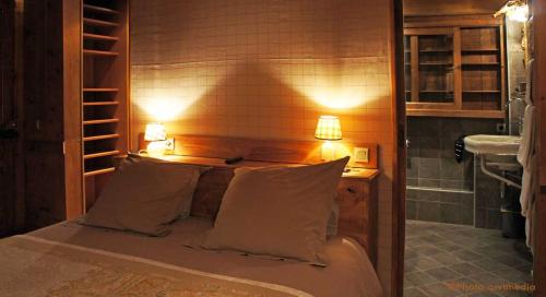 a bedroom with a bed with two pillows and a mirror at Chalet le 1791 in La Clusaz