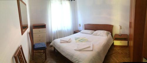 a bedroom with a bed with two towels on it at Apartments Ida Cres in Cres